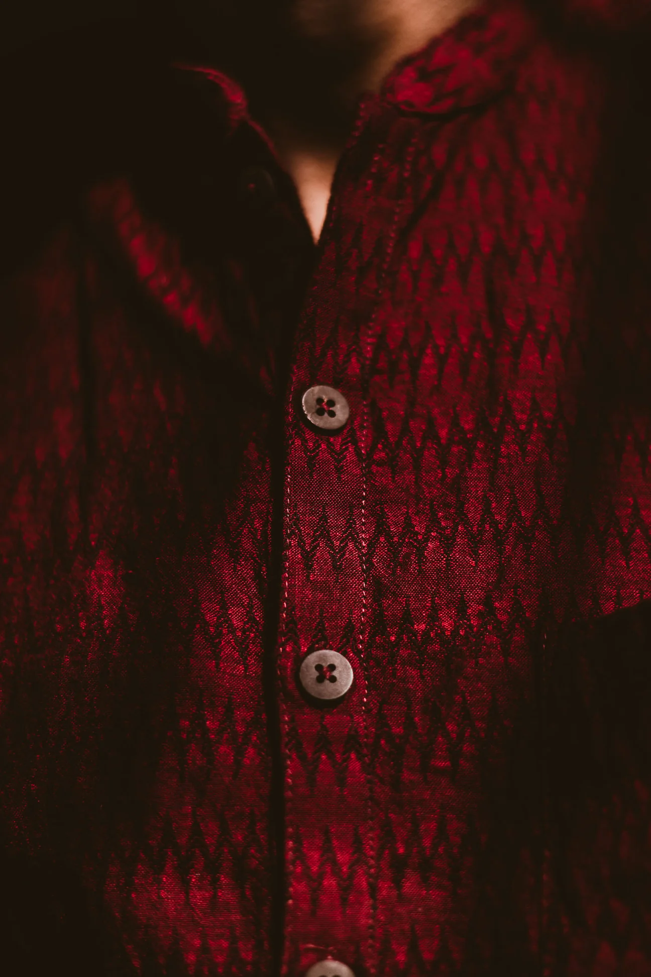 Close view of a madder red cardigan with wooden buttons