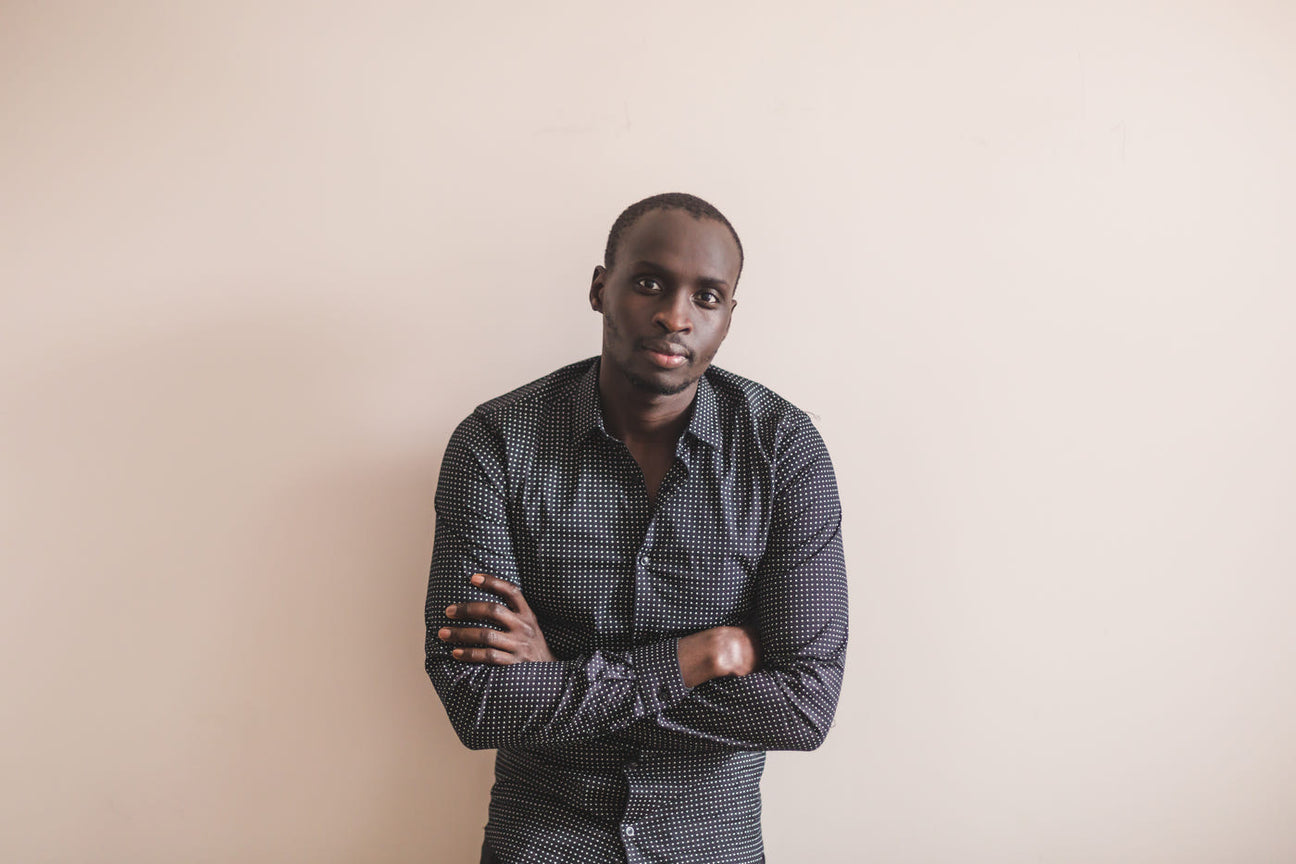 Man in a slate grey Oxford cotton shirt, arms folded