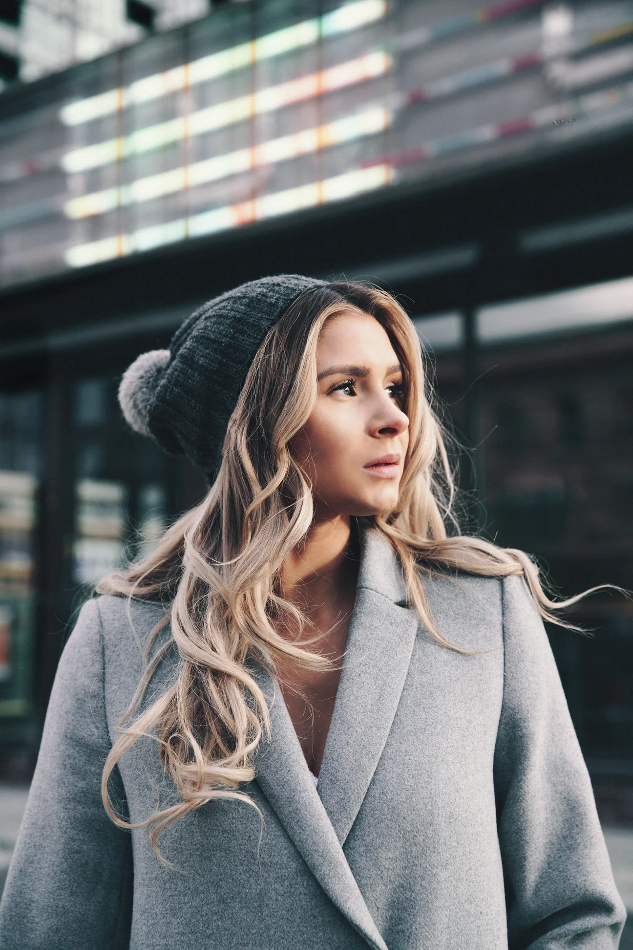 Woman in a dove grey double-faced wool coat and knitted hat