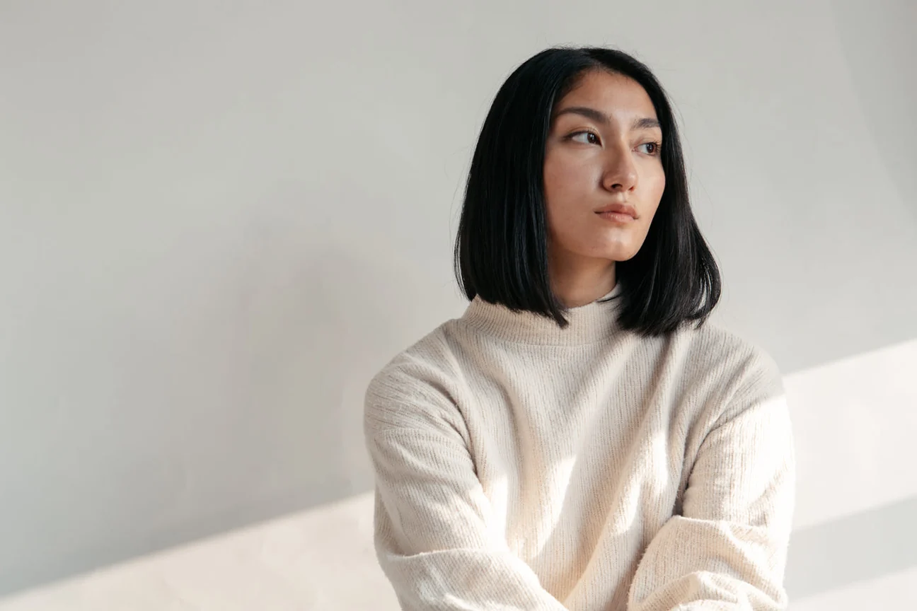 Woman in an ecru merino crewneck by a window
