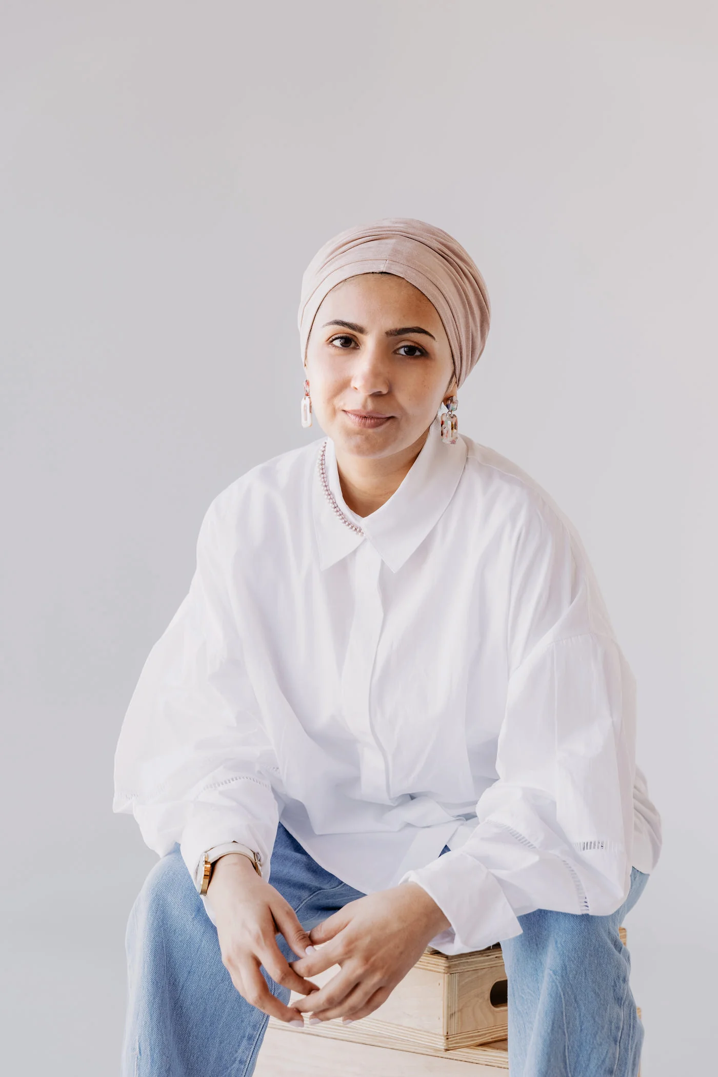 Woman seated in an oversized white poplin shirt